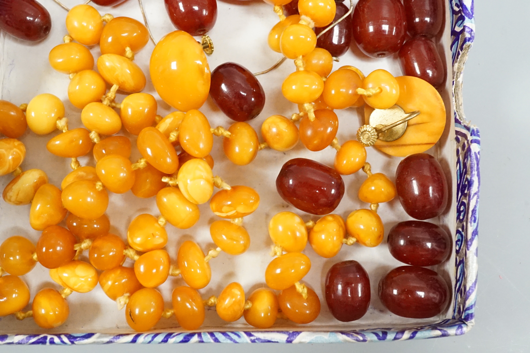 A single strand amber necklace, par of amber earrings and an amber pendant?(lacking fitting), gross weight 40 grams, together with a small quantity of loose simulated cherry amber beads.